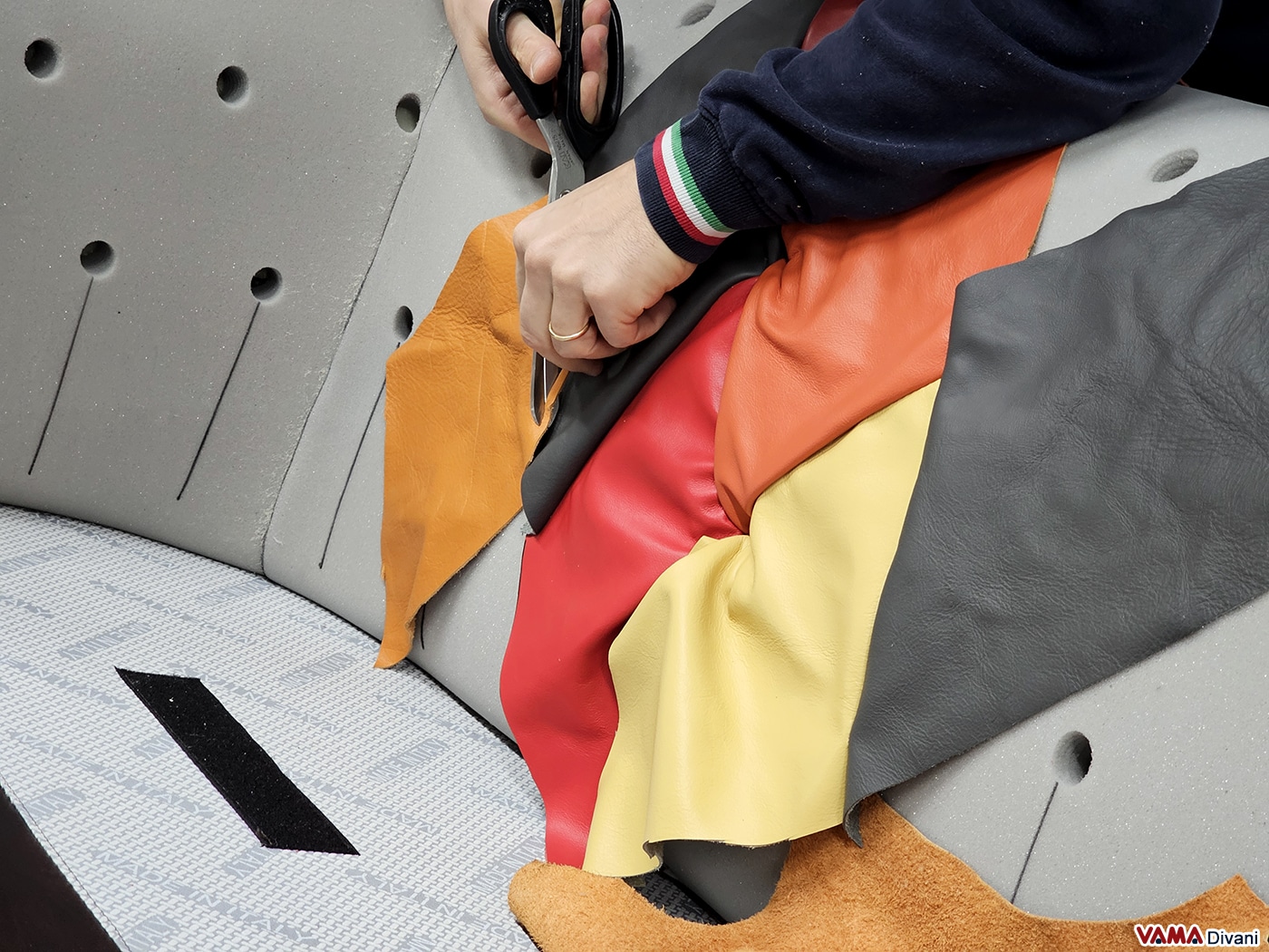 Hand-cutting custom leather patches for Harlequin Chesterfield sofa